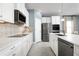 Bright kitchen with stainless steel appliances, white cabinets, stylish backsplash, and modern fixtures at 1310 Whispering Ln, Minneola, FL 34715
