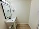 Modern bathroom featuring modern vanity with marble countertop, mirror, and wood floors at 232 Thomas Ave, Frostproof, FL 33843