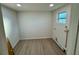 Bright laundry room with a window, clean white walls, and new wood floors at 232 Thomas Ave, Frostproof, FL 33843