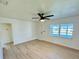 Bright living room with a ceiling fan and light hardwood floors, featuring abundant natural light from large windows at 232 Thomas Ave, Frostproof, FL 33843