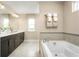 Bright bathroom featuring a soaking tub, sleek vanity with dark cabinets and neutral color palette at 3758 Voyageurs Ct, Apopka, FL 32712
