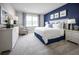This primary bedroom features a large window, blue accent wall, and stylish furnishings at 3758 Voyageurs Ct, Apopka, FL 32712