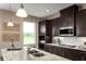 Contemporary kitchen with stainless steel appliances, granite countertops, and dark wood cabinets at 3758 Voyageurs Ct, Apopka, FL 32712