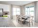 Adjacent dining area features a gray wooden table and seating for six with natural light from sliding glass doors at 7088 Lanier Falls Rd, Deland, FL 32724