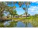 Expansive property featuring a picturesque pond, main house, and outbuildings surrounded by mature trees at 13700 Sw 108Th Ln, Dunnellon, FL 34432