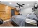 A stylish bedroom features wood accent wall, ceiling fan, and mounted TV at 13700 Sw 108Th Ln, Dunnellon, FL 34432
