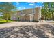 Spacious home with a large concrete driveway, lush landscaping, and a swimming pool at 13700 Sw 108Th Ln, Dunnellon, FL 34432