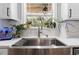Close up of stainless steel farmhouse style kitchen sink and faucet with garden view window at 13700 Sw 108Th Ln, Dunnellon, FL 34432