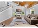 Living room with a fireplace, large windows, and wood ceiling with staircase to second floor at 13700 Sw 108Th Ln, Dunnellon, FL 34432