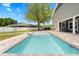 This outdoor pool area features a tanning ledge and a waterfall feature with a brick paver patio at 13700 Sw 108Th Ln, Dunnellon, FL 34432
