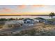 Aerial view of new construction homes on lakefront lots with open garage and sunset skies at 1556 Covey Rise Ter, Winter Haven, FL 33884