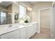 Bright bathroom features double vanities, white countertops, stylish fixtures, and a glass-enclosed shower at 1556 Covey Rise Ter, Winter Haven, FL 33884