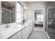 Bathroom with double vanity, quartz countertops, a shower, and natural light at 1556 Covey Rise Ter, Winter Haven, FL 33884