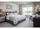 Bright bedroom with a lake view, patterned bedding, and a cozy seating area at 1556 Covey Rise Ter, Winter Haven, FL 33884