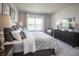 Bedroom with patterned bedding, a dark dresser, and a picturesque lake view at 1556 Covey Rise Ter, Winter Haven, FL 33884
