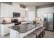 Bright kitchen featuring stainless steel appliances, granite counters, white cabinets and a central island at 1556 Covey Rise Ter, Winter Haven, FL 33884