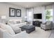 Cozy living room with white sofas, gray ottoman, TV, and large windows offering serene view at 1556 Covey Rise Ter, Winter Haven, FL 33884