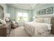 Light-filled main bedroom featuring a tray ceiling, a neutral palette, and large windows with views of green fields at 1556 Covey Rise Ter, Winter Haven, FL 33884