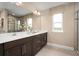 Elegant bathroom with dual sinks, dark wood cabinetry, quartz countertops, and a glass-enclosed shower at 3186 Tiger Palm Way, New Smyrna Beach, FL 32168