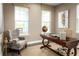 Well-lit home office featuring a wooden desk, comfortable seating, and large windows perfect for focused work at 3186 Tiger Palm Way, New Smyrna Beach, FL 32168