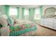 Bright bedroom with a colorful bed, complemented by sheer curtains and a white dresser with gold accents at 3190 Tiger Palm Way, New Smyrna Beach, FL 32168