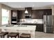 Modern kitchen featuring stainless steel appliances, granite countertops, and dark wood cabinets at 3190 Tiger Palm Way, New Smyrna Beach, FL 32168