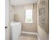 Functional laundry room with a modern washer and dryer, complemented by neutral tones and a geometric-patterned artwork at 3190 Tiger Palm Way, New Smyrna Beach, FL 32168