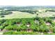 Aerial view of property showcasing home nestled among trees, surrounded by large, open green fields at 2955 Se 156Th Place Rd, Summerfield, FL 34491