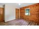 Charming bedroom featuring natural wood wall accent, wood-look floors, a ceiling fan, and a window at 2955 Se 156Th Place Rd, Summerfield, FL 34491