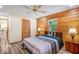 Bedroom featuring wood-look floors, wood paneling, and a ceiling fan at 2955 Se 156Th Place Rd, Summerfield, FL 34491