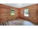 Bright bedroom featuring hardwood paneled walls, two windows, and wood-look flooring at 2955 Se 156Th Place Rd, Summerfield, FL 34491
