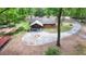 Log cabin showcasing a large circular driveway, covered parking, and serene woodland backdrop at 2955 Se 156Th Place Rd, Summerfield, FL 34491
