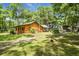 Scenic log cabin showcasing a covered porch, lush lawn, and convenient car port at 2955 Se 156Th Place Rd, Summerfield, FL 34491
