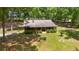 Quaint log cabin with a charming porch and manicured landscaping surrounded by lush trees at 2955 Se 156Th Place Rd, Summerfield, FL 34491