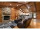 Spacious living room with a stone fireplace, wood paneled ceiling, and an open layout to the kitchen area at 2955 Se 156Th Place Rd, Summerfield, FL 34491