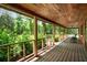 Spacious covered porch with wood ceilings, railing, and outdoor views at 2955 Se 156Th Place Rd, Summerfield, FL 34491