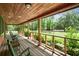 Relaxing covered porch featuring wooden floors, railing, and views of the serene outdoors at 2955 Se 156Th Place Rd, Summerfield, FL 34491