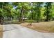 Scenic view of a well-maintained property featuring a long driveway leading to a charming log cabin home at 2955 Se 156Th Place Rd, Summerfield, FL 34491