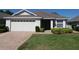 Charming one-story home with well-maintained landscaping, a brick driveway, and a two-car garage at 3806 Osprey Pointe Cir, Winter Haven, FL 33884