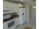 Bright kitchen with white cabinets and appliances, showcasing ample counter space and tile flooring at 3806 Osprey Pointe Cir, Winter Haven, FL 33884