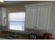 Kitchen with white cabinetry, double sink, and a sunlit window, highlighting a practical layout at 3806 Osprey Pointe Cir, Winter Haven, FL 33884
