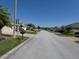 Neighborhood street view showcasing well-maintained homes and green lawns under a clear sky at 3806 Osprey Pointe Cir, Winter Haven, FL 33884
