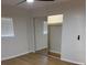 Bright bedroom with wood floors, mirrored closet, and window with horizontal blinds at 601 Lantern Ln, Orange City, FL 32763