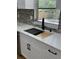 Modern kitchen sink with quartz countertops, matte black fixtures, and mosaic backsplash at 601 Lantern Ln, Orange City, FL 32763