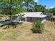 An aerial view of the gray home with a metal roof, a big yard and large trees around the property at 201 Lake Gene Dr, Longwood, FL 32779