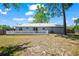 Backyard with a wooden fence, mature trees, green grass, and a house with a metal roof at 201 Lake Gene Dr, Longwood, FL 32779