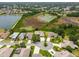 Aerial view showcasing a community near a lake and wetland with well-kept lawns and homes on a sunny day at 27223 Nostalgia Dr, Leesburg, FL 34748