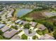 Beautiful aerial view of a residential community featuring lush landscaping, a serene lake, and well-maintained homes at 27223 Nostalgia Dr, Leesburg, FL 34748