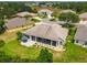 Aerial view of a house with a screened in back porch with seating, landscaping and grass at 27223 Nostalgia Dr, Leesburg, FL 34748