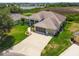 Aerial view of a beautiful home near a pond, surrounded by lush greenery and landscaping at 27223 Nostalgia Dr, Leesburg, FL 34748